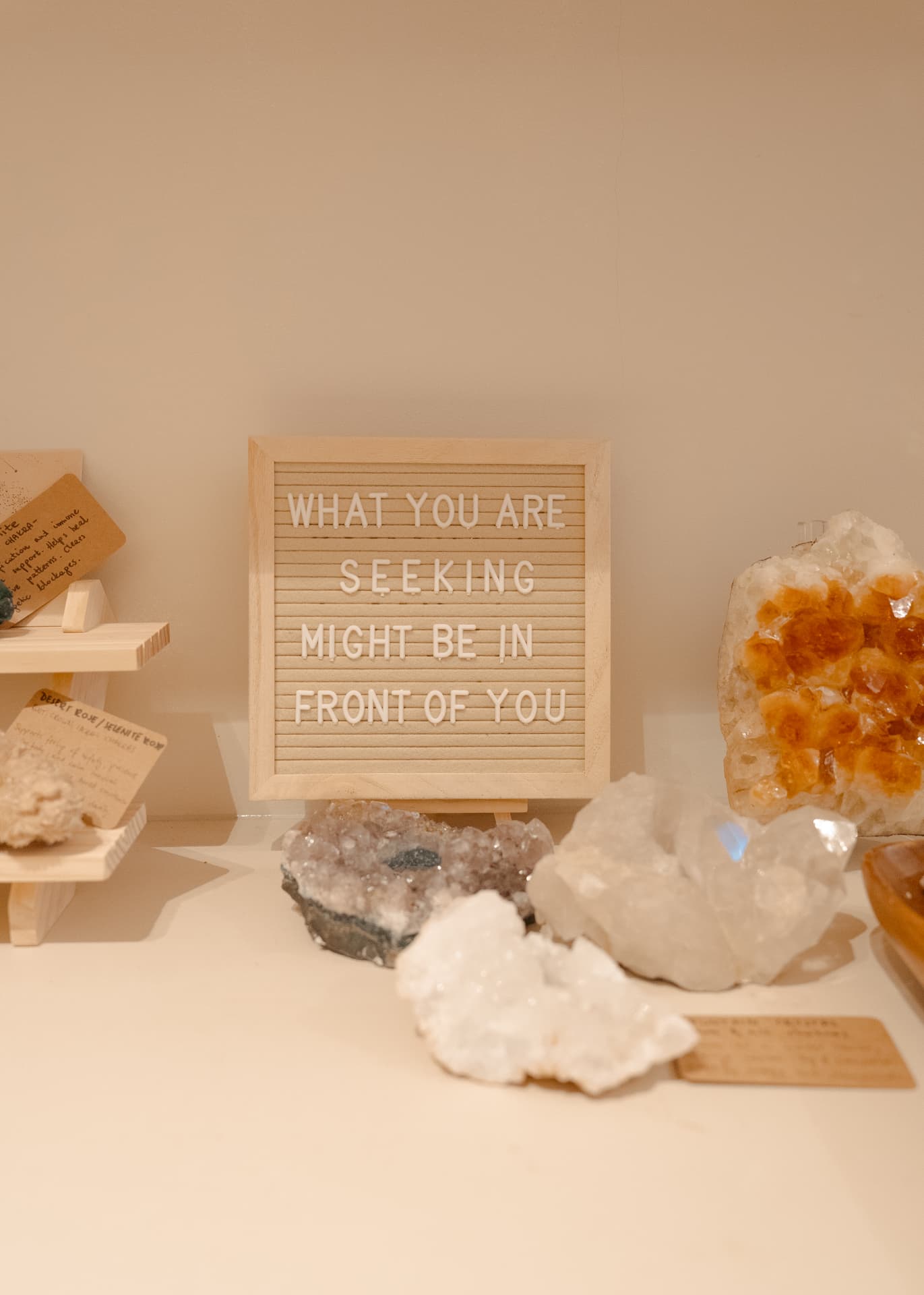 Letter board reading What you are seeking might be in front of you, with crystals