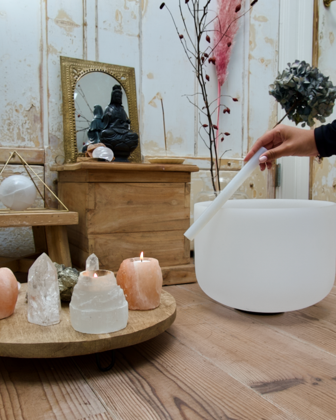 A crystal singing bowl with candles and an altar